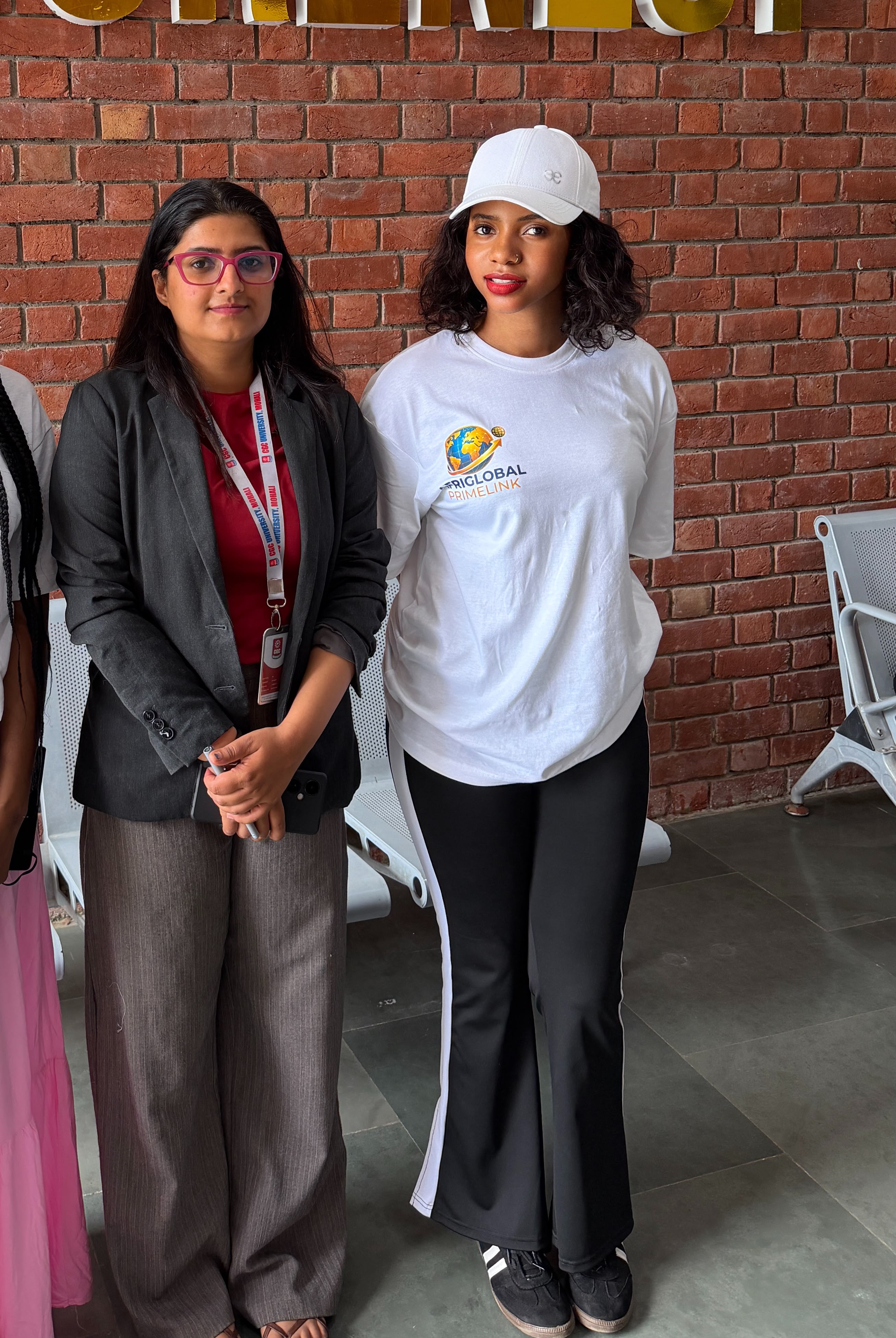 Two AfriGlobal representatives in front of the CGC VentureNest brick wall