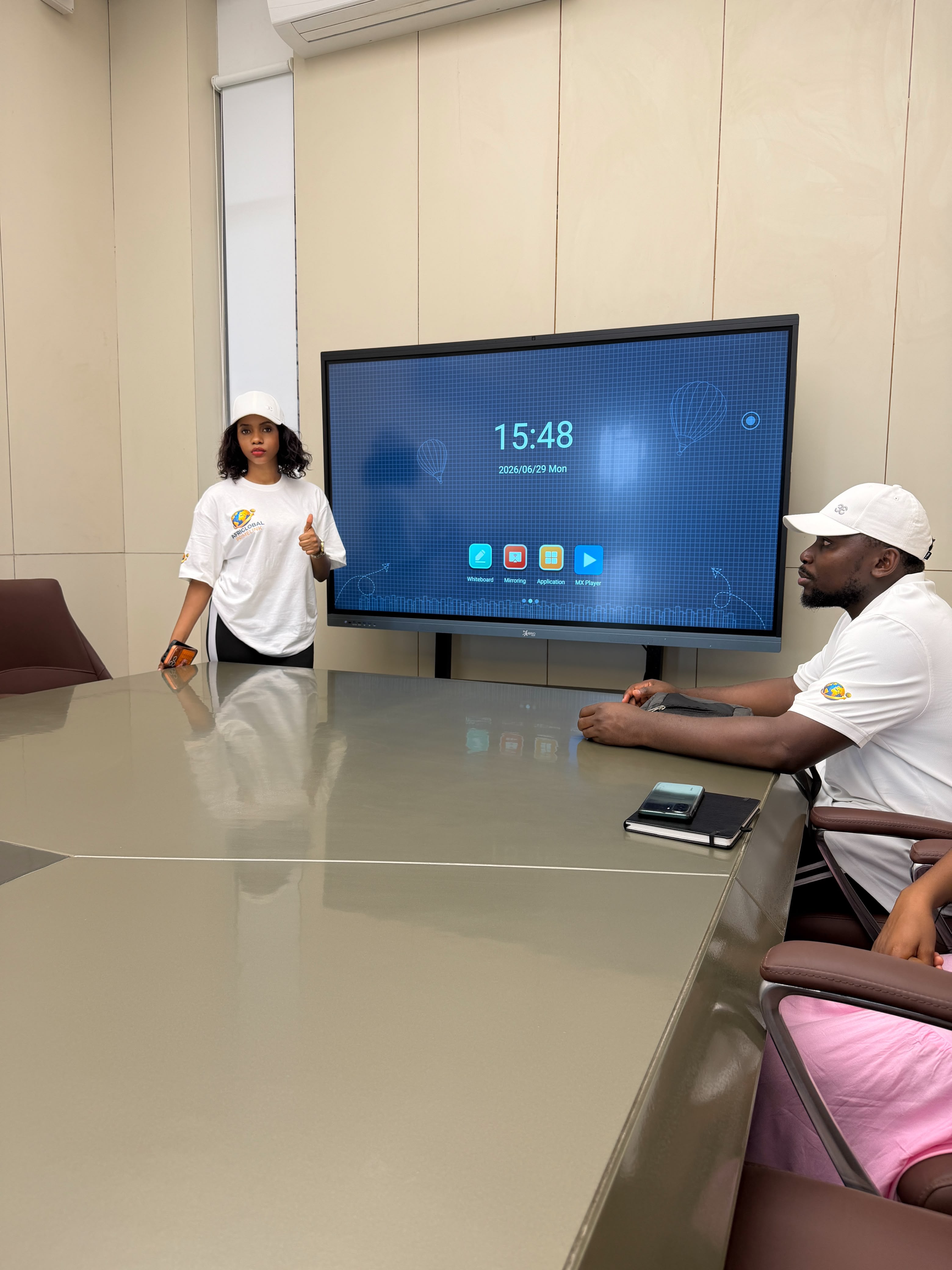 An AfriGlobal representative presenting beside a smart display in a CGC meeting room