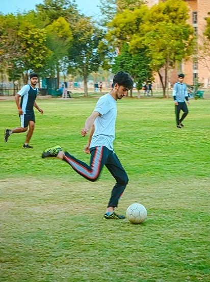Students playing football on the CGC University campus green