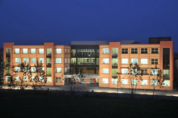 An academic block at MM University lit up at dusk